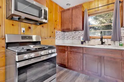 a kitchen with a stove and a microwave at Juniper Lakeside Couples Resort Cabin by Big Bear Vacations in Big Bear Lake