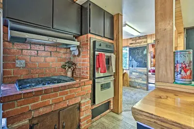 a brick kitchen with an oven and a brick wall at Expansive Retreat with Deck, Game Room and Lake Views! in Lake Arrowhead
