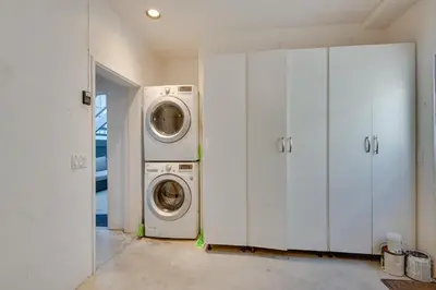 a laundry room with two washing machines and cabinets at Beachfront Malibu House with Sauna and Ocean-View Deck in Malibu