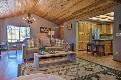 a living room with a couch and a table at Spacious Pine Mtn Club Cabin with Game Room and Deck in Pine Mountain Club