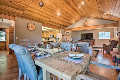 a dining room and living room with a wooden ceiling at Spacious Pine Mtn Club Cabin with Game Room and Deck in Pine Mountain Club