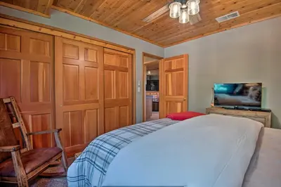 a bedroom with a bed and a flat screen tv at Spacious Pine Mtn Club Cabin with Game Room and Deck in Pine Mountain Club