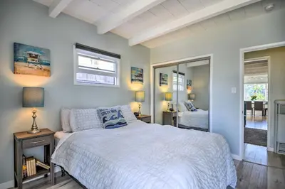 a bedroom with a white bed and a mirror at Remodeled Ventura Beach Home with Yard and Fire Pit! in Ventura