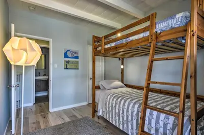 a bedroom with two bunk beds and a bathroom at Remodeled Ventura Beach Home with Yard and Fire Pit! in Ventura