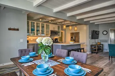 a dining room table with blue dishes and a vase of flowers at Remodeled Ventura Beach Home with Yard and Fire Pit! in Ventura