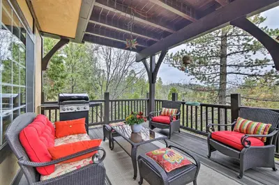 a porch with chairs and a table and a grill at Luxe Lake Arrowhead Home with Deck, 3 Mi to Village! in Lake Arrowhead
