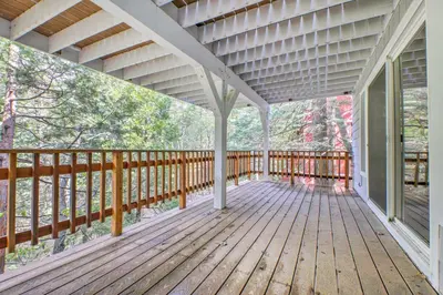 a wooden deck with a view of the woods at Gorgeous Lake Arrowhead Retreat Game Room and Deck in Lake Arrowhead