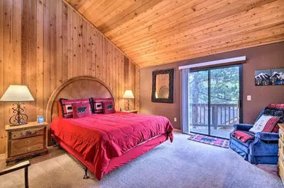 a bedroom with a large red bed and a chair at Hike, Ski, Fish Big Bear Lake Lodge with Deck in Big Bear Lake