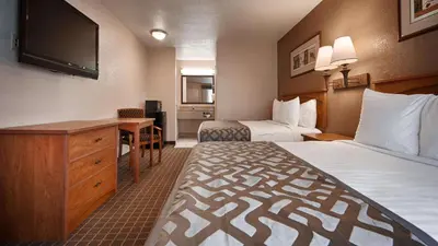 a hotel room with two beds and a desk at Cajon Pass Inn in Cajon Junction