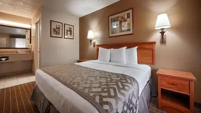a hotel room with a large bed and a bathroom at Cajon Pass Inn in Cajon Junction
