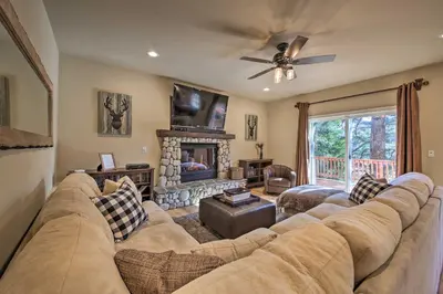 a living room with a large couch and a fireplace at Sugar Bear Lodge with Game Room - 5 Mi to Village! in Lake Arrowhead