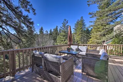a deck with chairs and a table and an umbrella at Sugar Bear Lodge with Game Room - 5 Mi to Village! in Lake Arrowhead