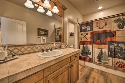 a bathroom with a sink and a large mirror at Sugar Bear Lodge with Game Room - 5 Mi to Village! in Lake Arrowhead