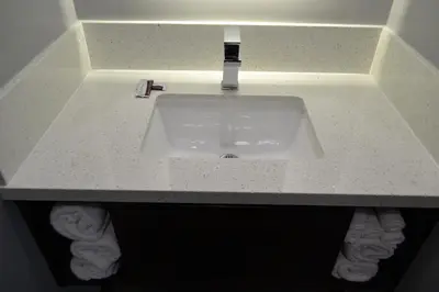 a sink in a bathroom with towels under it at Bell Gardens Inn Los Angeles - Bell Gardens in Bell Gardens