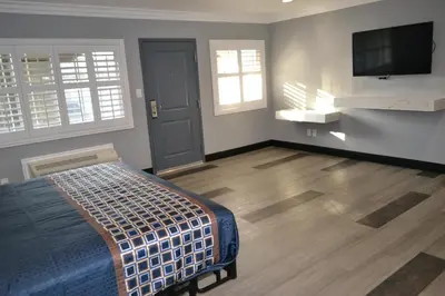 a bedroom with a bed and a flat screen tv at Bell Gardens Inn Los Angeles - Bell Gardens in Bell Gardens