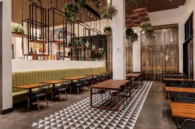 a row of tables and chairs in a restaurant at The Glenmark, Glendale, a Tribute Portfolio Hotel in Glendale