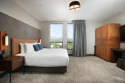 a hotel room with a bed and a large window at The Glenmark, Glendale, a Tribute Portfolio Hotel in Glendale
