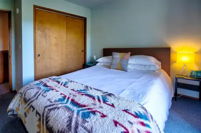 a bedroom with a large bed with a blanket on it at The Atomic Squirrel Lodge Lake Gregory Getaway! in Crestline