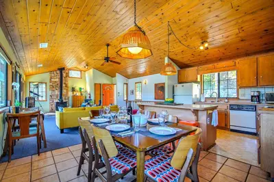 a kitchen and dining room with a table and chairs at The Atomic Squirrel Lodge Lake Gregory Getaway! in Crestline
