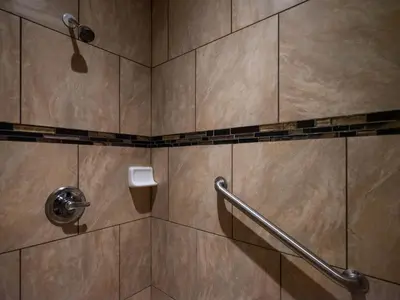 a bathroom with a shower with a hand rail at Parkside Inn in Long Beach