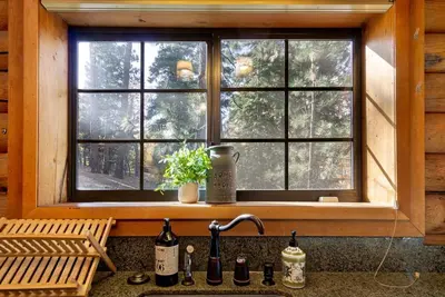 a kitchen sink with a window in a log cabin at Woodland Log-1887 by Big Bear Vacations in Big Bear Lake