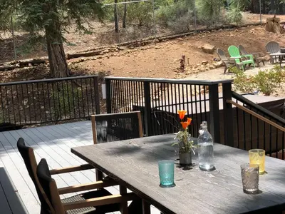 a wooden table with flowers on a deck at Woodland Log-1887 by Big Bear Vacations in Big Bear Lake