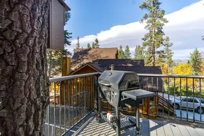 a grill on the deck of a house at Woodland Log-1887 by Big Bear Vacations in Big Bear Lake