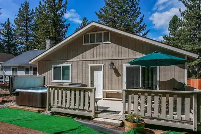 a small house with a deck and an umbrella at Kitkats Hideaway-1874 by Big Bear Vacations in Big Bear Lake