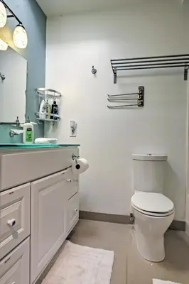 a bathroom with a white toilet and a sink at 3 Mi to Dtwn Dining! Long Beach Condo with Balcony in Long Beach