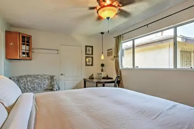 a bedroom with a bed and a chair and a window at 3 Mi to Dtwn Dining! Long Beach Condo with Balcony in Long Beach