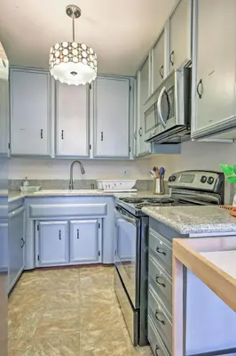 a kitchen with white cabinets and a sink at Downtown Long Beach Condo - 1 Mi to Boardwalk! in Long Beach