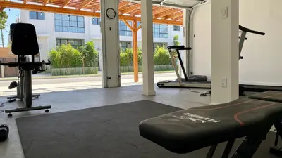 a gym with a treadmill and exercise equipment in a building at Hollywood's Garden Paradise at World Artists Living in Los Angeles