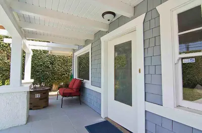 a porch with a red chair on a house at Hollywood's Garden Paradise at World Artists Living in Los Angeles