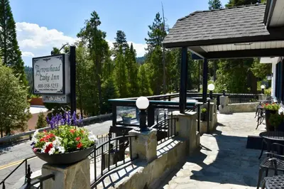 a building with a sign and flowers in a pot at Arrowhead Lake Inn in Lake Arrowhead