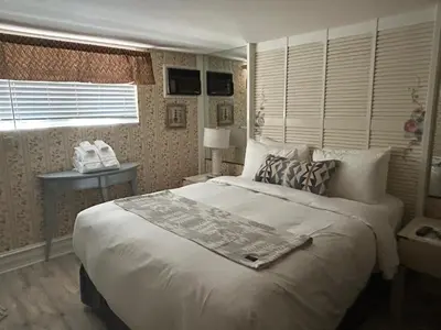 a bedroom with a large bed and a window at Arrowhead Lake Inn in Lake Arrowhead