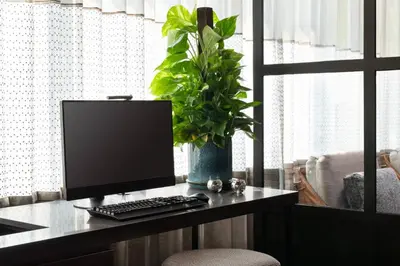 a desk with a computer monitor and a plant on it at Residence Inn Los Angeles Glendale in Glendale