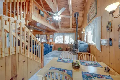 a dining room and living room in a log cabin at Mountain Tops Ponderosa Getaway Near Dome Rock! in Ponderosa