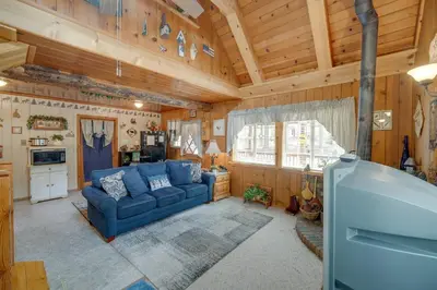 a living room with a blue couch in a cabin at Mountain Tops Ponderosa Getaway Near Dome Rock! in Ponderosa