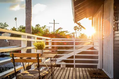 a wooden porch with a bench and the sun shining at Pet-Friendly Stay, Mins to Beach, Conv Ctr, Prkg LB B in Long Beach