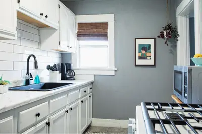 a kitchen with white cabinets and a sink and a window at Pet-Friendly Stay, Mins to Beach, Conv Ctr, Prkg LB B in Long Beach