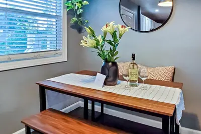 a table with a bottle of wine and a vase of flowers at Traveler's Pick Cozy, Near Beach & Dtwn,Prkg LB C in Long Beach