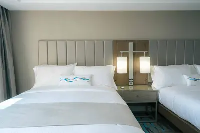 a bedroom with two beds and a cross on the wall at H2O Hermosa Beach Hotel in Hermosa Beach