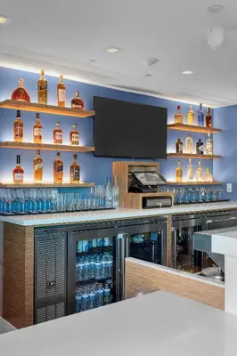 a bar with a display of bottles of whiskey at H2O Hermosa Beach Hotel in Hermosa Beach