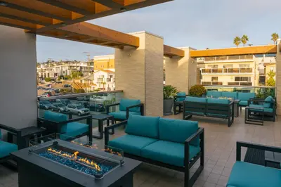 a patio with blue chairs and a fire pit at H2O Hermosa Beach Hotel in Hermosa Beach