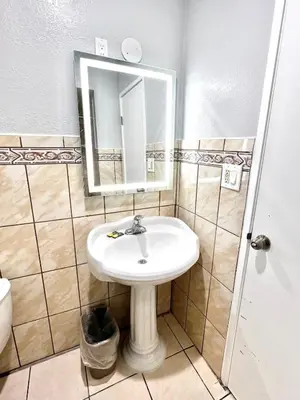 a bathroom with a sink and a mirror at Aqua Inn Motel in El Monte