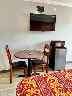 a room with a table and two chairs and a television at Aqua Inn Motel in El Monte