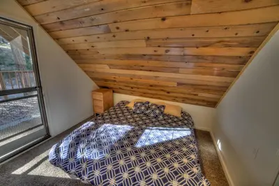 a bed in a room with a wooden ceiling at sequoia National Forest CabinH in Panorama Heights