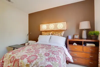 a bedroom with a bed with a floral bedspread and a dresser at Single-Story San Bernardino Home with Valley Views! in San Bernardino