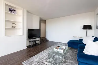 a living room with a blue couch and a tv at Skyline Views 1-Bedroom with Balcony and Pool in Los Angeles
