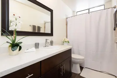 a bathroom with a sink and a toilet and a mirror at Skyline Views 1-Bedroom with Balcony and Pool in Los Angeles